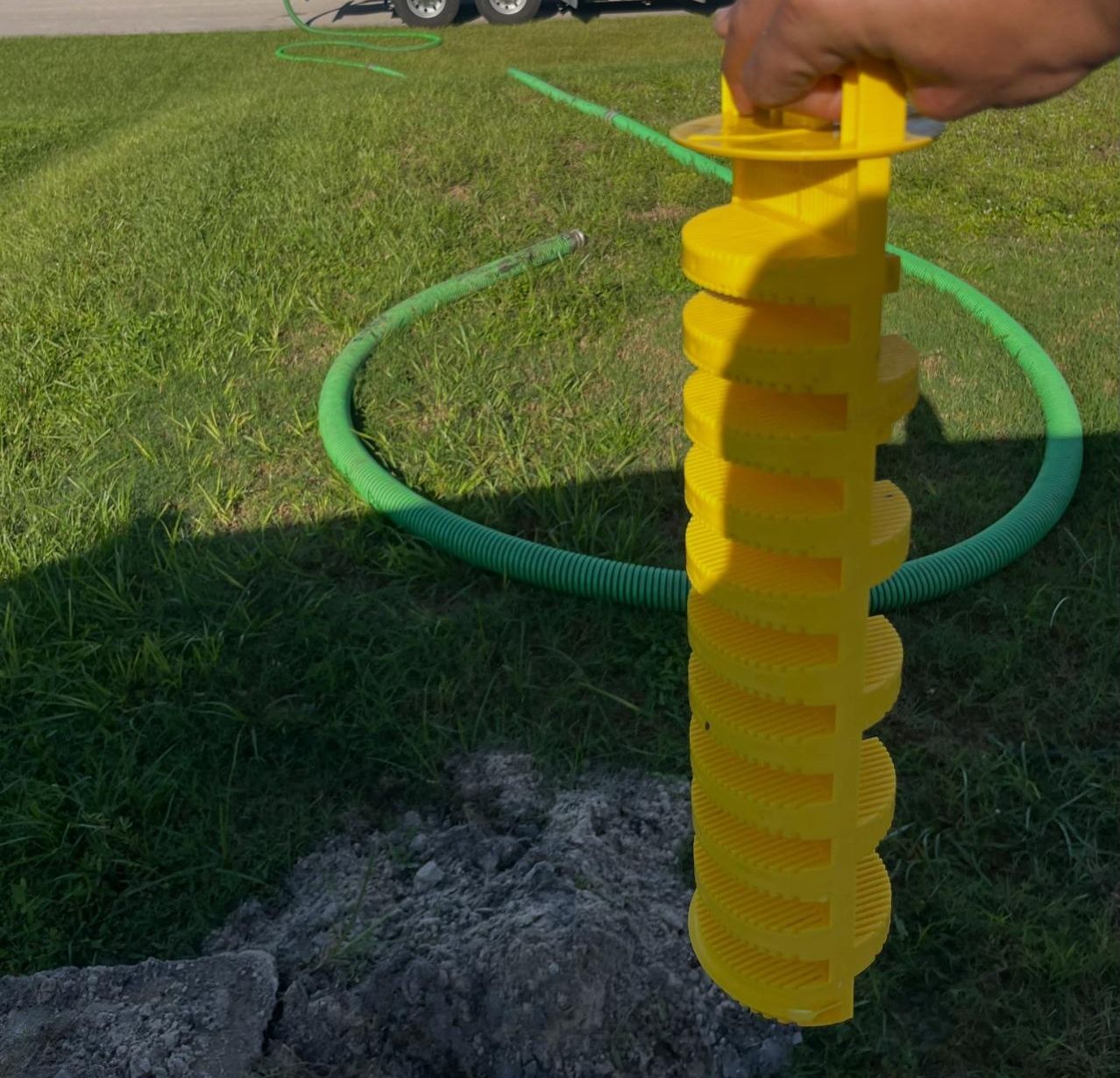 Yellow septic riser extension being set on a tank opening
